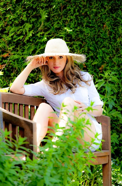 Jovem mulher relaxando no jardim quando — Fotografia de Stock