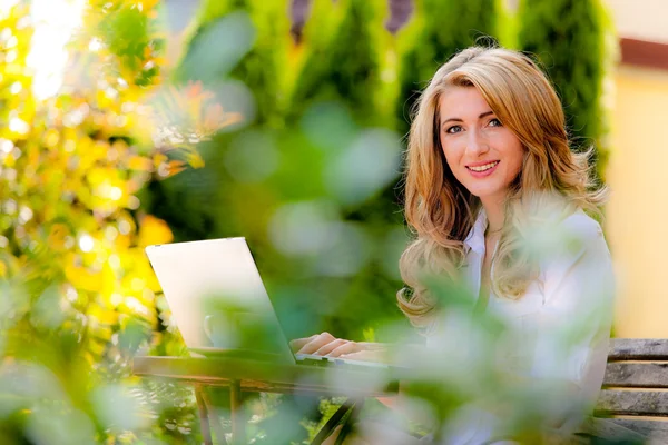 Γυναίκα με φορητό υπολογιστή στον κήπο — Φωτογραφία Αρχείου