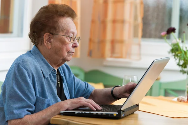 Donna anziana attiva con computer portatile nel tempo libero — Foto Stock