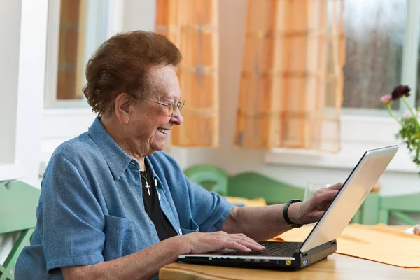 Donna anziana attiva con computer portatile nel tempo libero — Foto Stock