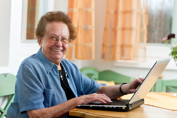 レジャーでのラップトップを持つアクティブな年配の女性 — ストック写真