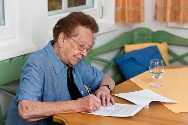 Старший подписывает контракт — стоковое фото