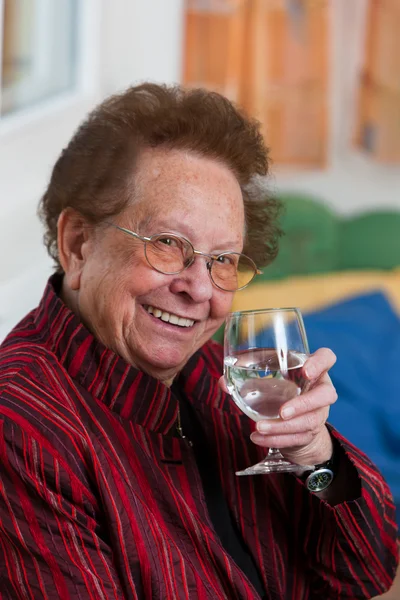 Oudere vrouw drinking water uit een glas — Stockfoto