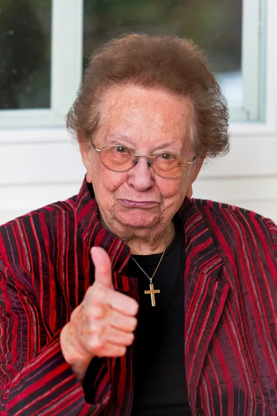 Başarılı yaşlı kadın yukarı başparmak ile gülüyor — Stok fotoğraf