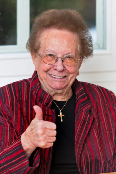 Başarılı yaşlı kadın yukarı başparmak ile gülüyor — Stok fotoğraf