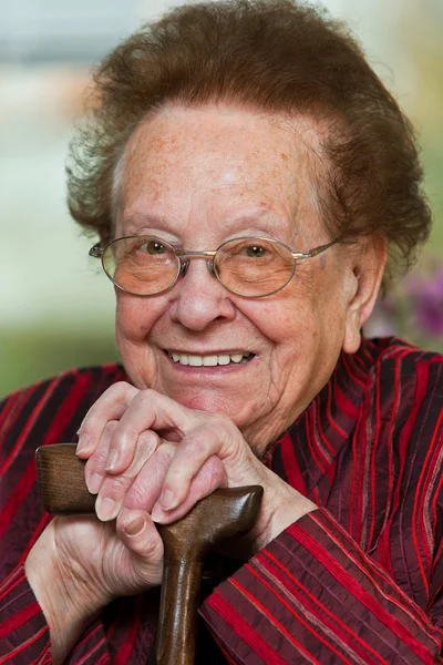 Funktionshindrade äldre kvinna med en vandrande käpp med ett leende — Stockfoto