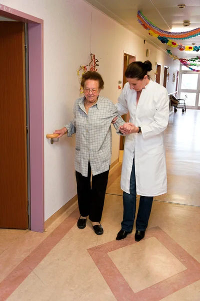 Enfermeras supervisadas anciana en un asilo de ancianos — Foto de Stock