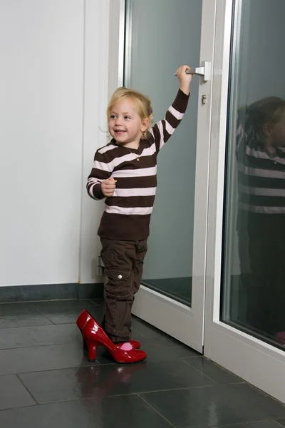 Παιδί με μεγάλα παπούτσια ανοίγει μια πόρτα — Φωτογραφία Αρχείου
