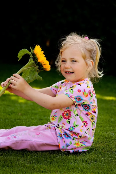 Kind mit Sonnenblume im Garten im Sommer — Stockfoto