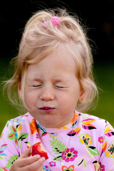 Kind isst Erdbeere im Garten — Stockfoto