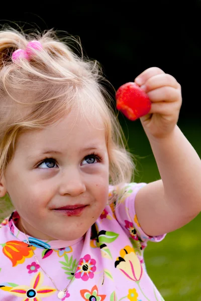 stock image Child eating a strawberry in the garden