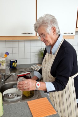 Senior with the washing of her dishes clipart