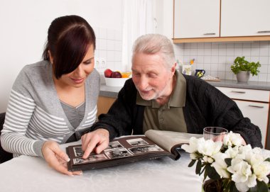 Woman looks at a photo album with seniors clipart