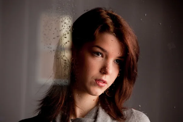 Chica joven solitaria pensativa en la ventana —  Fotos de Stock