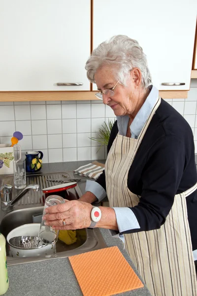Seniorin beim Geschirrspülen — Stockfoto