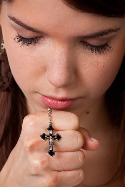 Девушки молятся руками с крестом — стоковое фото