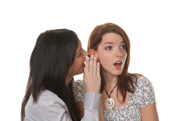 Twee jonge vrouwen fluisteren met elkaar zijn verbonden — Stockfoto