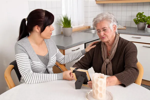 Una mujer consolando a una viuda después de la muerte. consejería de duelo . — Foto de Stock