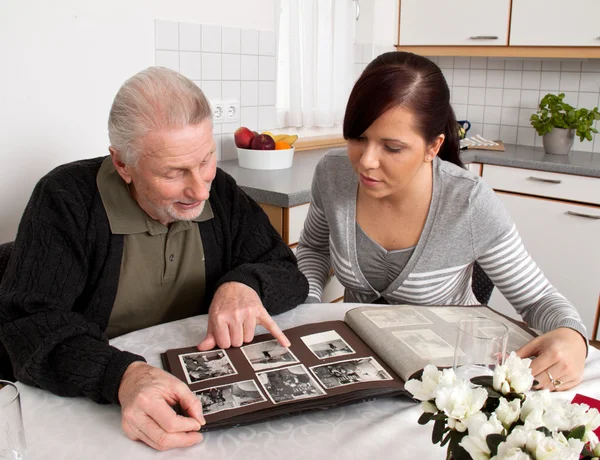 Nő ránéz egy fotóalbumot nyugdíjasainkkal — Stock Fotó