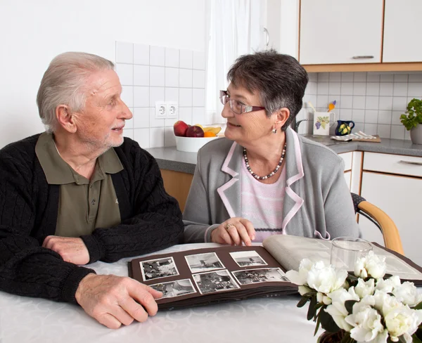 Glãƒâ ¼ ckliches elderly couple looks at photo album. — Stock Fotó