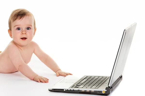 Klein kind met een laptopcomputer tijdens het afspelen — Stockfoto