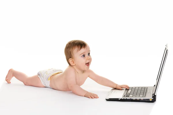 Маленький ребенок с ноутбуком во время игры — стоковое фото