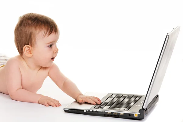 Klein kind met een laptopcomputer tijdens het afspelen — Stockfoto