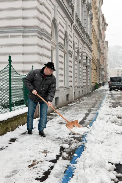 Vaktmästare medger trottoaren av snö — Stockfoto