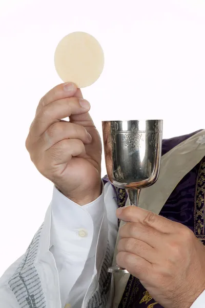 Католический священник, с чашей и патеном на святом причастии — стоковое фото