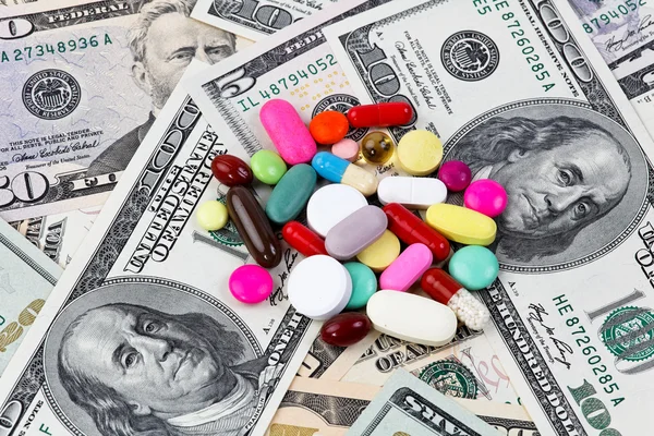 Koszty dla zdrowia, tabletki i Dolar rachunki — Zdjęcie stockowe