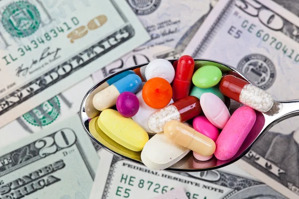 Dollar och tabletter, en symbol för hälso-och sjukvårdskostnader — Stockfoto