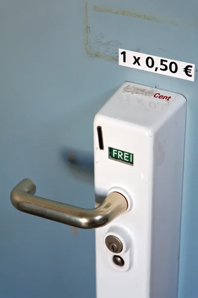 Detail of a door handle with dial tone münztoilette — Stock fotografie