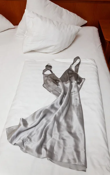 Nightgown on bed in hotel room — Stock Photo, Image