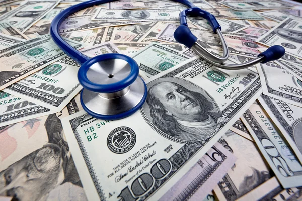 Costi per salute, stetoscopio e banconote in dollari Immagine Stock