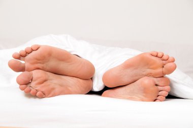 Feet of couple in bed. separation and divorce clipart
