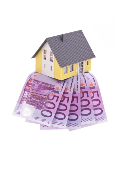 Muchos billetes de euros y una casa — Foto de Stock
