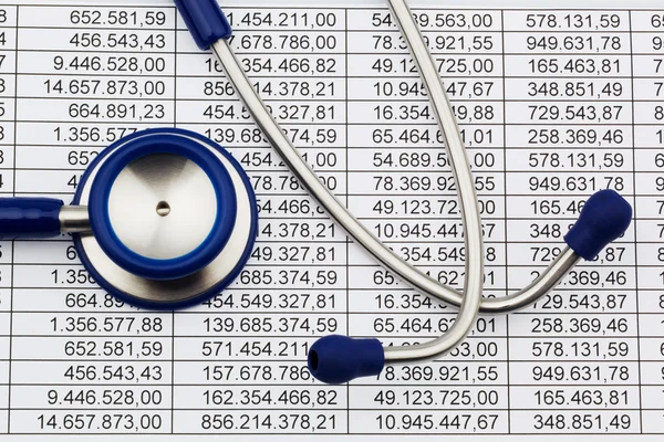 Balance sheet figures and stethoscope — Stock Photo, Image