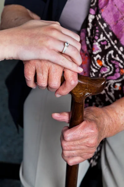Old and young hand with walking stick — Stock Photo, Image