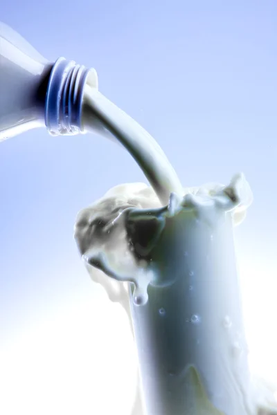 Despejar leite fresco cremoso em um copo transparente — Fotografia de Stock