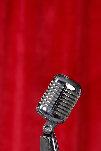 Microphone in front of red curtain — Stock Photo, Image