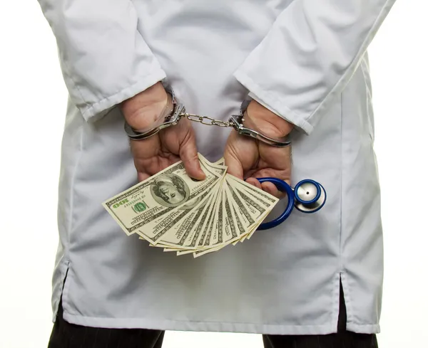 Doctor con billetes de dólar y esposas — Foto de Stock
