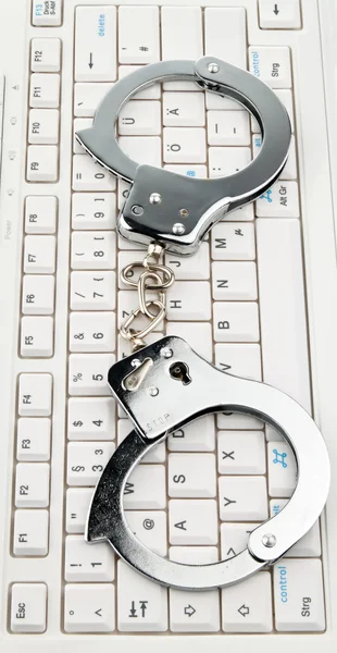 Computer keyboard handcuffs. cyber ??crime.