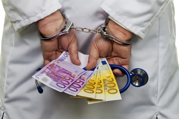 € physician bills and handcuffs — Stock Photo, Image