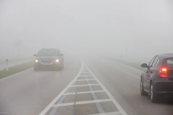 Voitures sur une route dans le brouillard — Photo