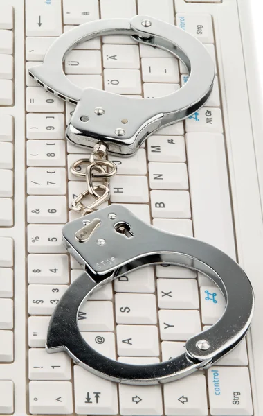 Handschellen für die Computertastatur. Cyber? Verbrechen?. — Stockfoto