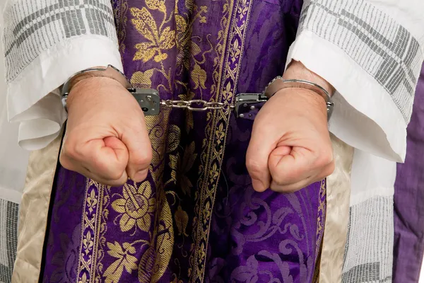 Abuse in the church. priest with handcuffs — Stock Photo, Image