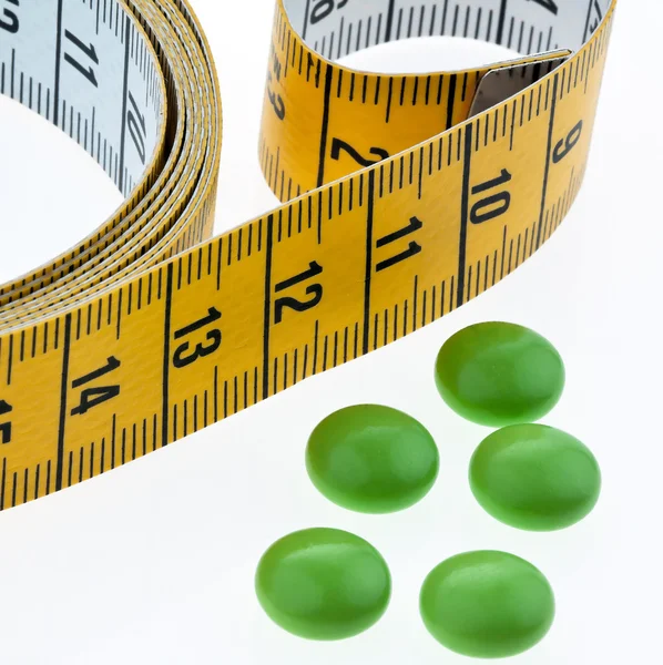 Fita métrica e comprimidos, como um símbolo para pil dieta — Fotografia de Stock