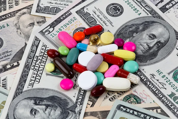 Расходы на здоровье, таблетки и долларовые купюры — стоковое фото