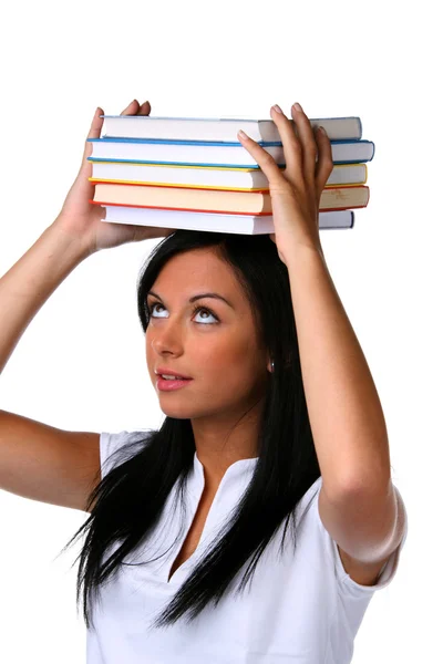 Ung kvinna med en hög med böcker på huvud — Stockfoto