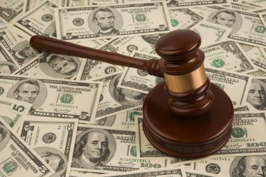 Law gavel on a stack of American money. clipart